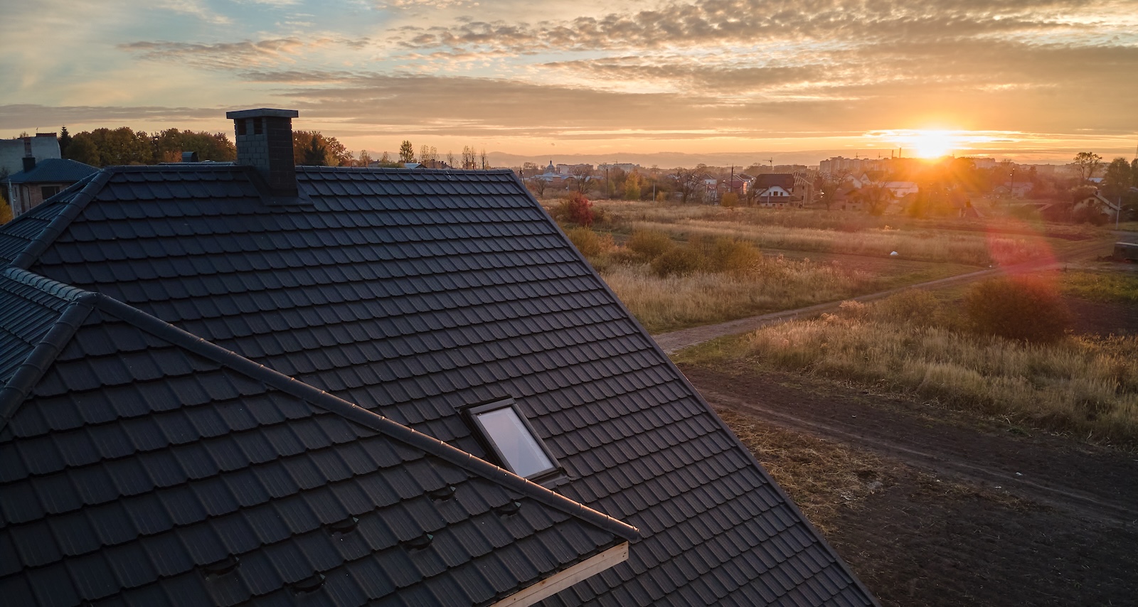 Closeup of house roof top covered with ceramic shingles. Tiled covering of building
