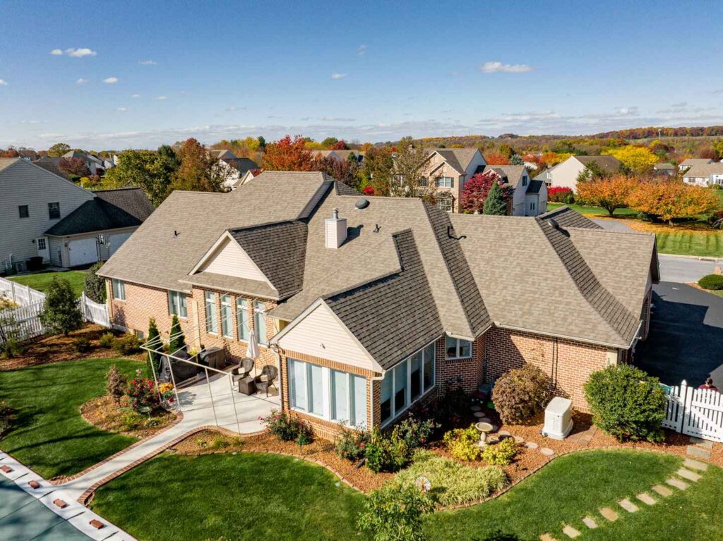 aerial view of a home with a tan asphalt shingle roof